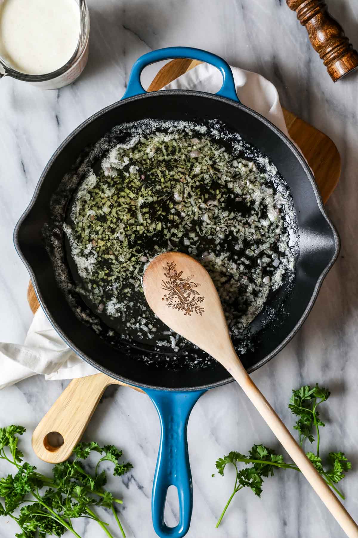 Overhead view of shallot cooking in butter and olive oil.