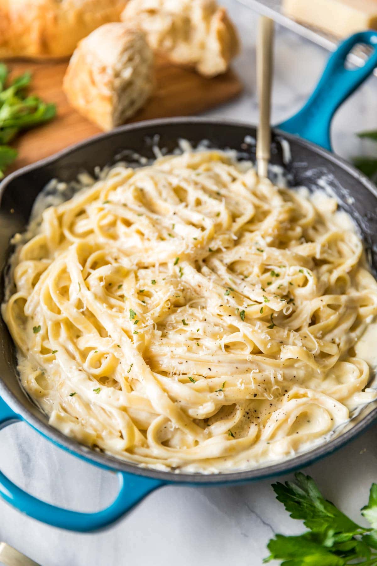 Skillet of fettucine tossed in alfredo sauce.