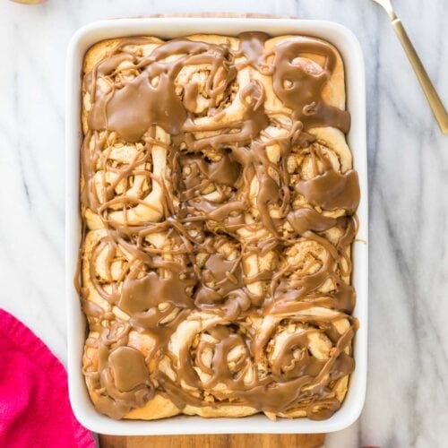 Baking dish full of caramel-glazed apple cinnamon rolls
