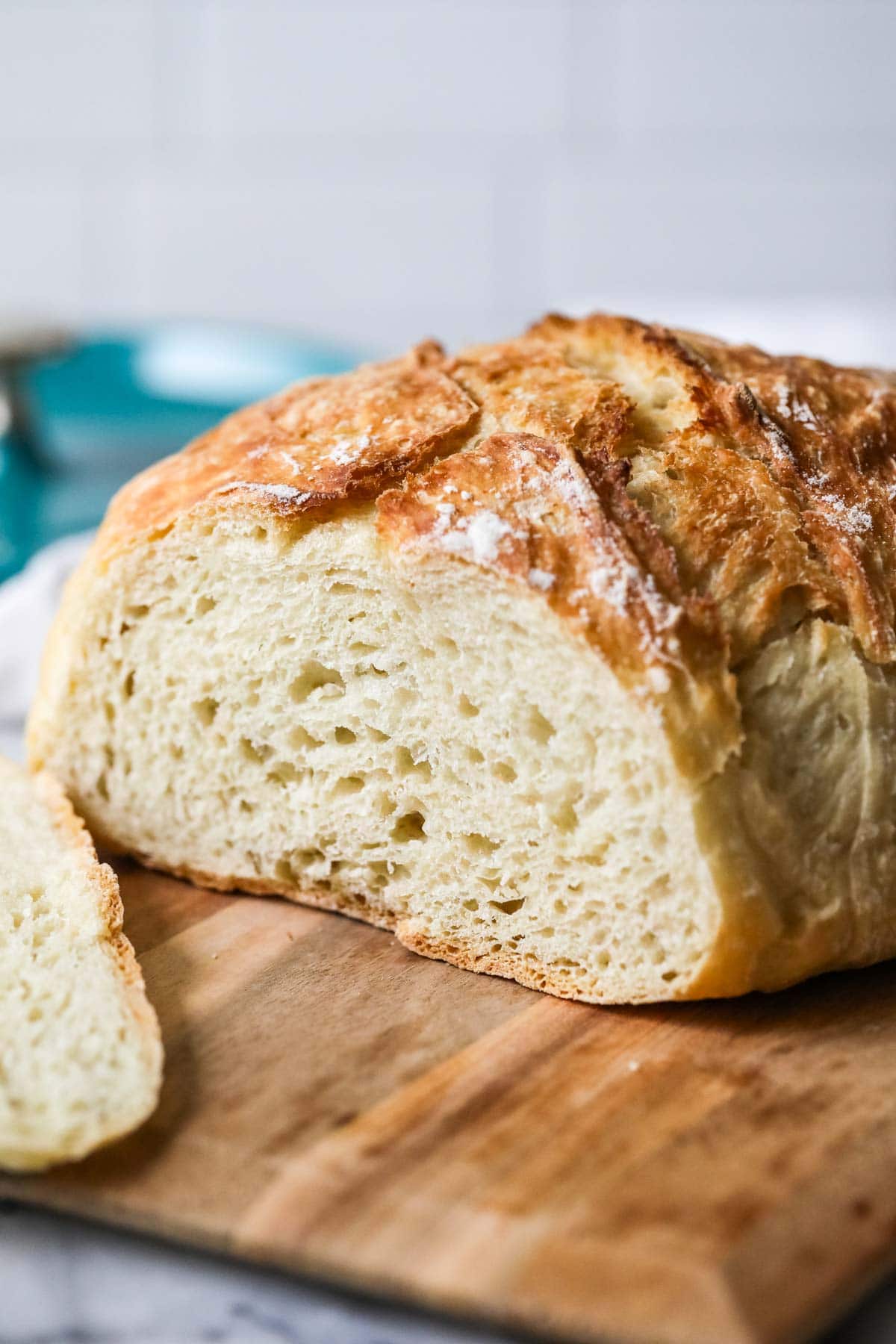 Loaf of crusty bread with one slice missing.