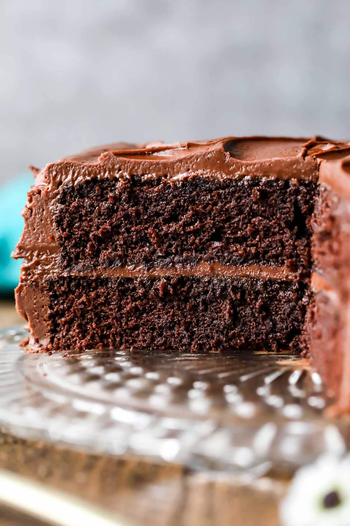 Cross section of a moist and fudgy chocolate cake on a glass serving platter.