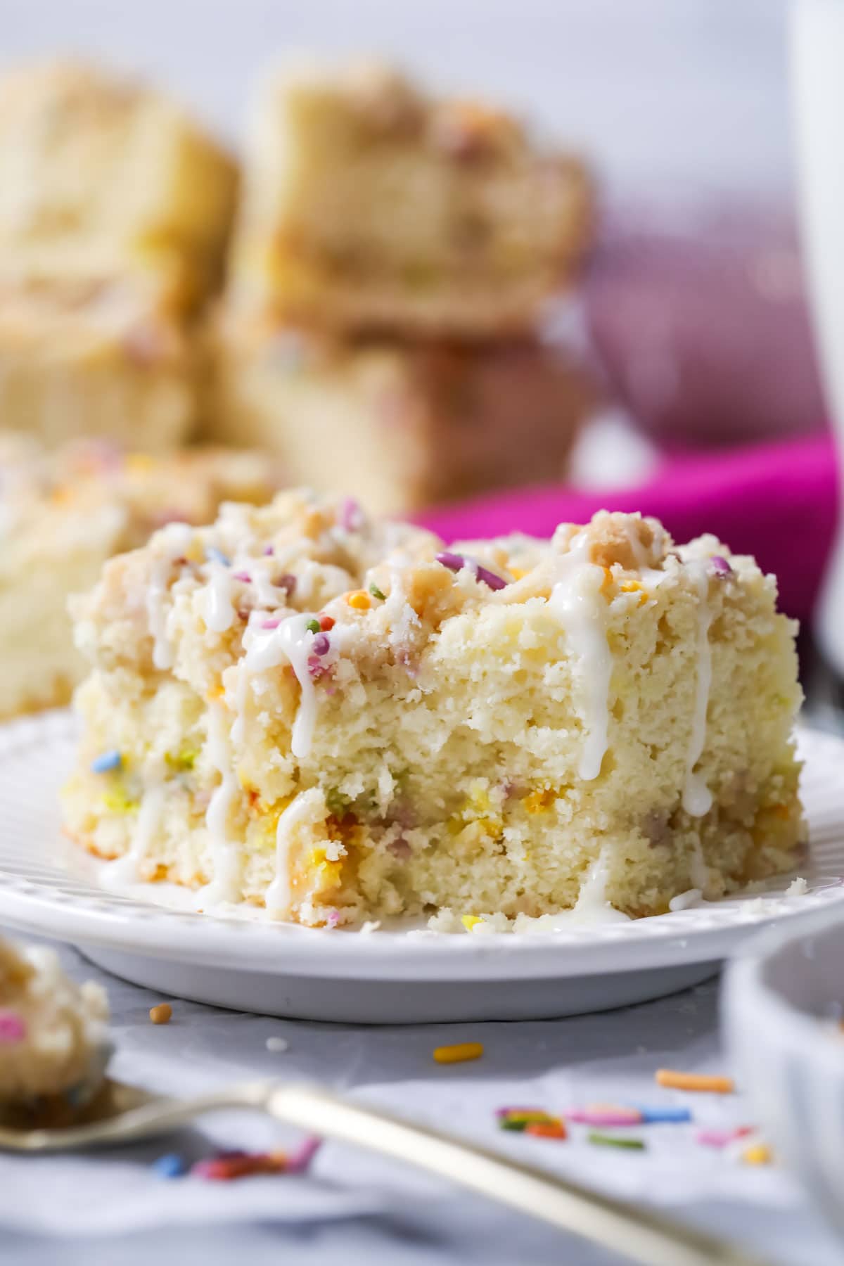 Slice of birthday crumb cake with one bite missing.