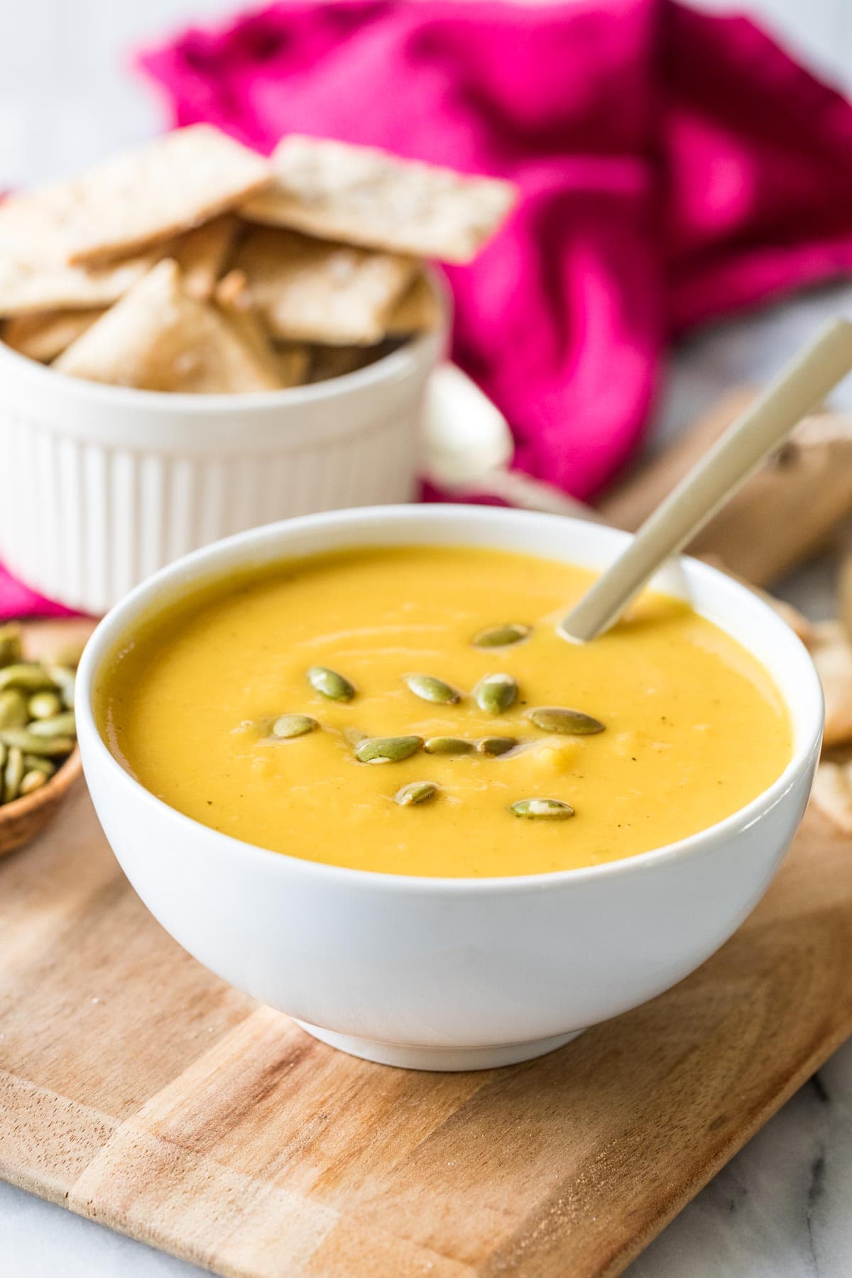 Bowl of butternut squash soup topped with roasted pumpkin seeds.