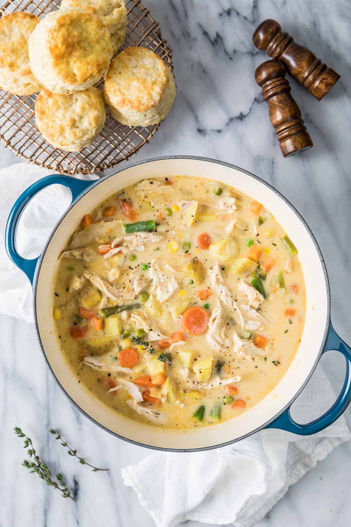 Overhead view of a pot of creamy chicken soup with vegetables.