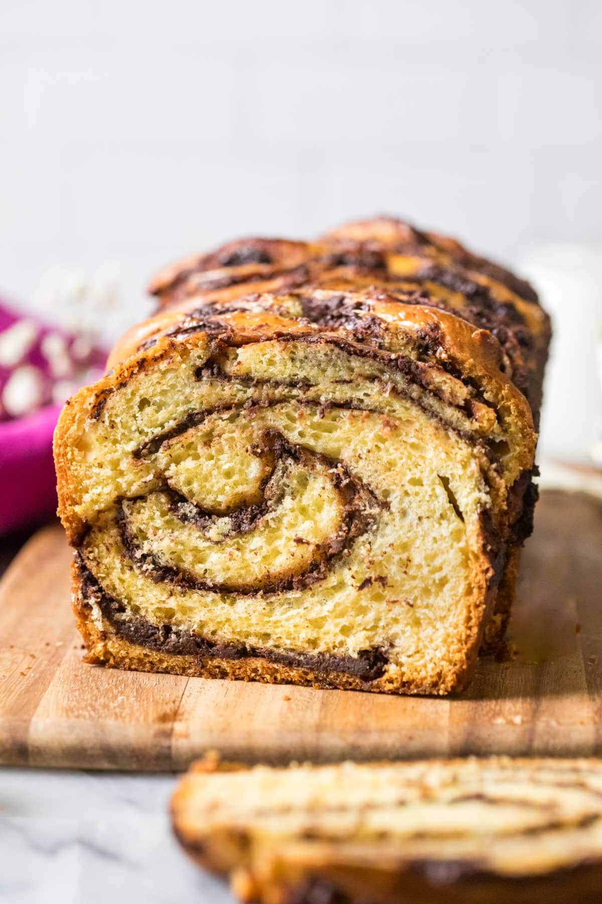 Swirled chocolate bread loaf on a wood cutting board.