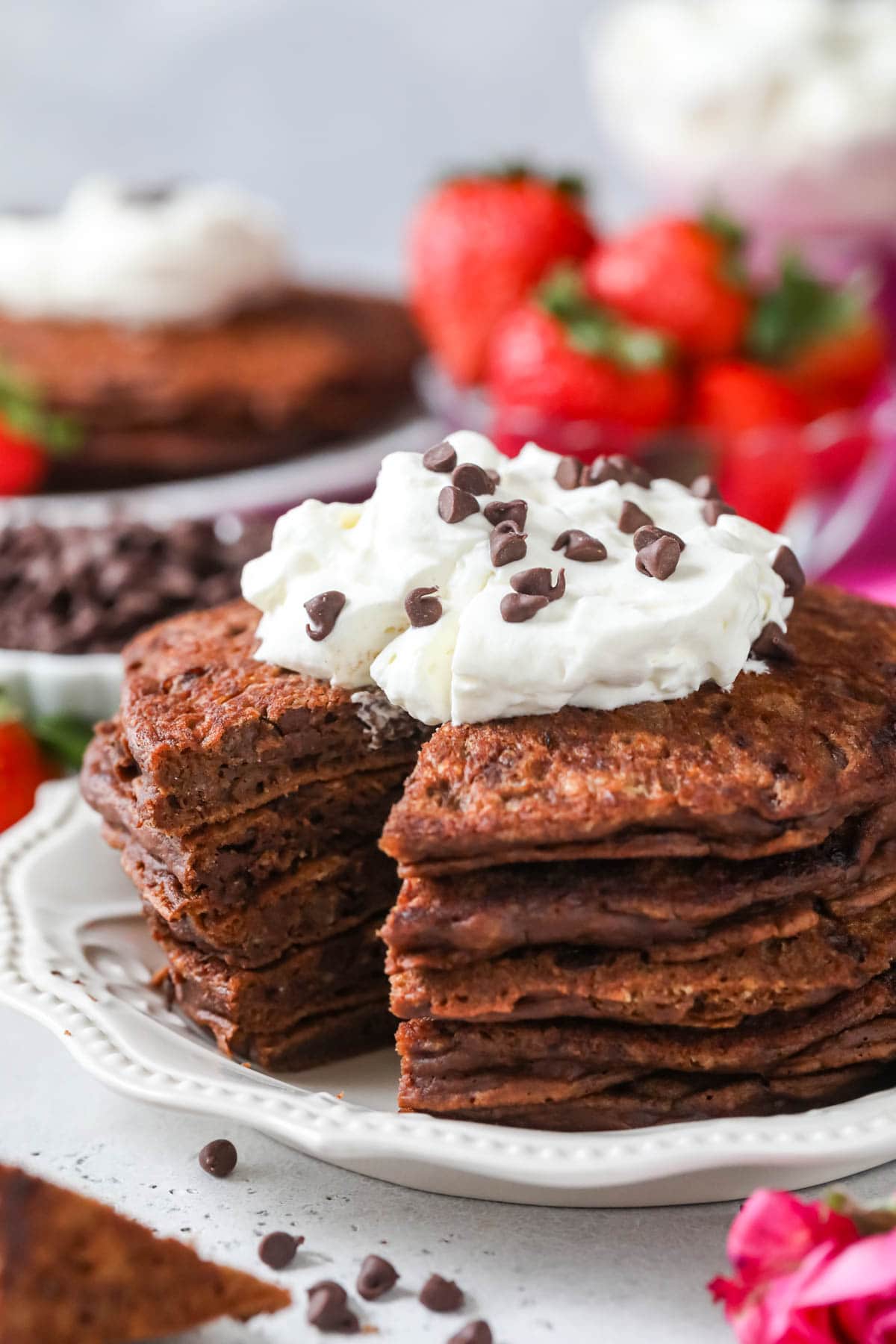 Stack of pancakes made with cocoa powder and chocolate chips with one cut section removed.