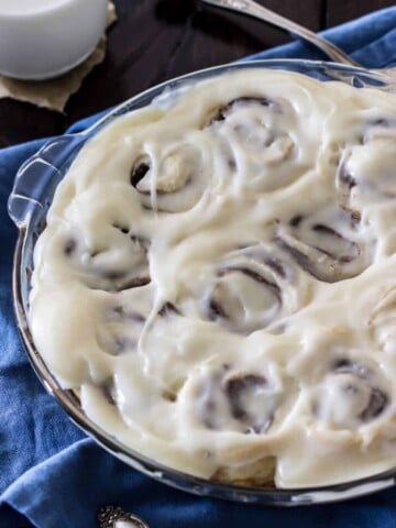 Iced cinnamon rolls in a glass pie dish