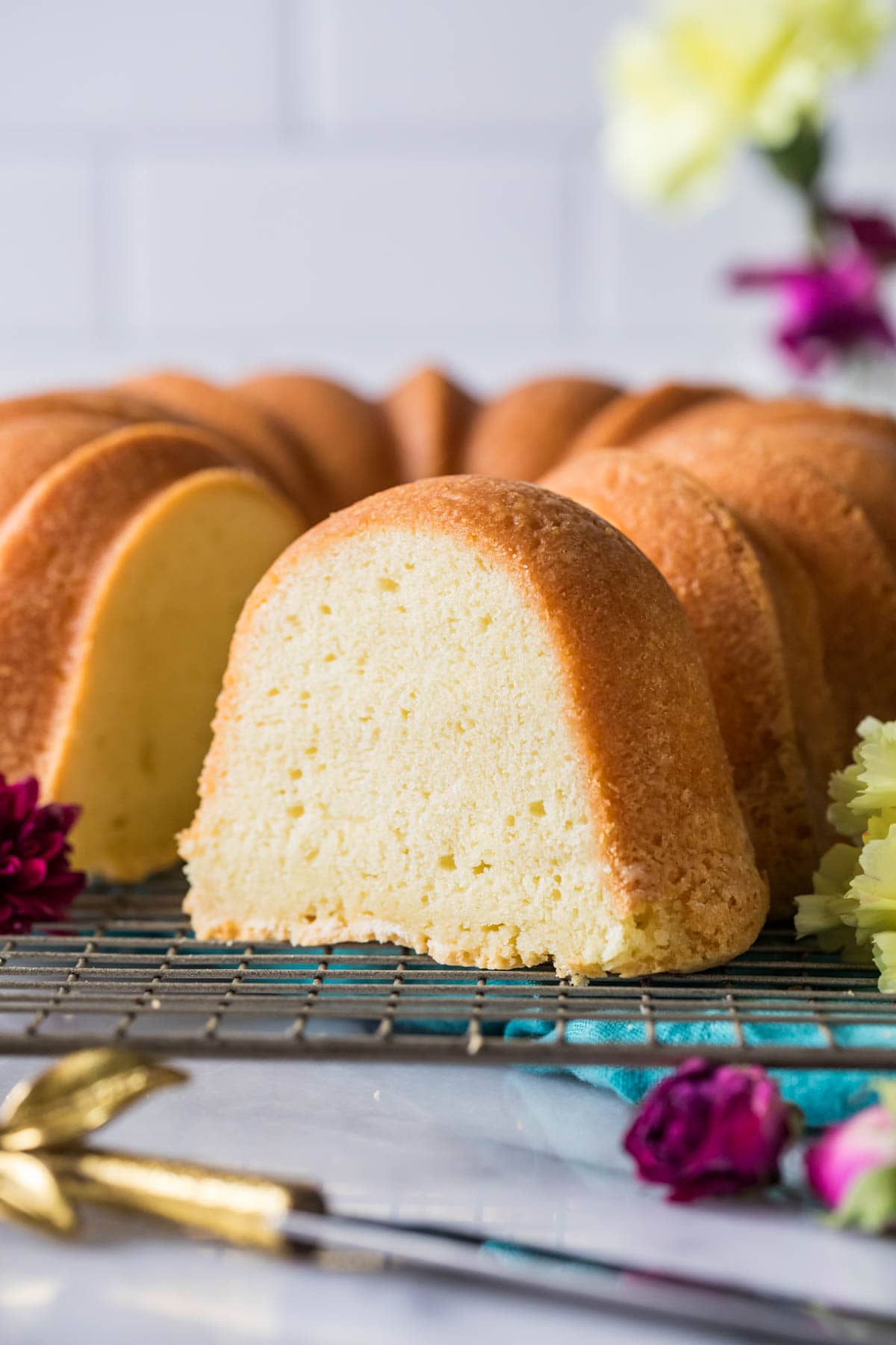Slice of cream cheese pound cake with the remaining cake behind it.