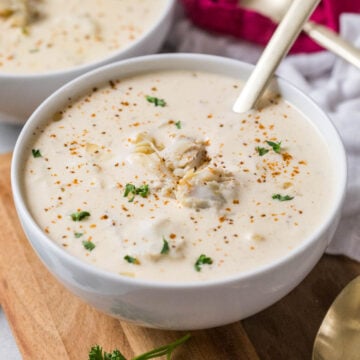 Bowl of cream of crab soup topped with old bay, parsley, and crab meat.
