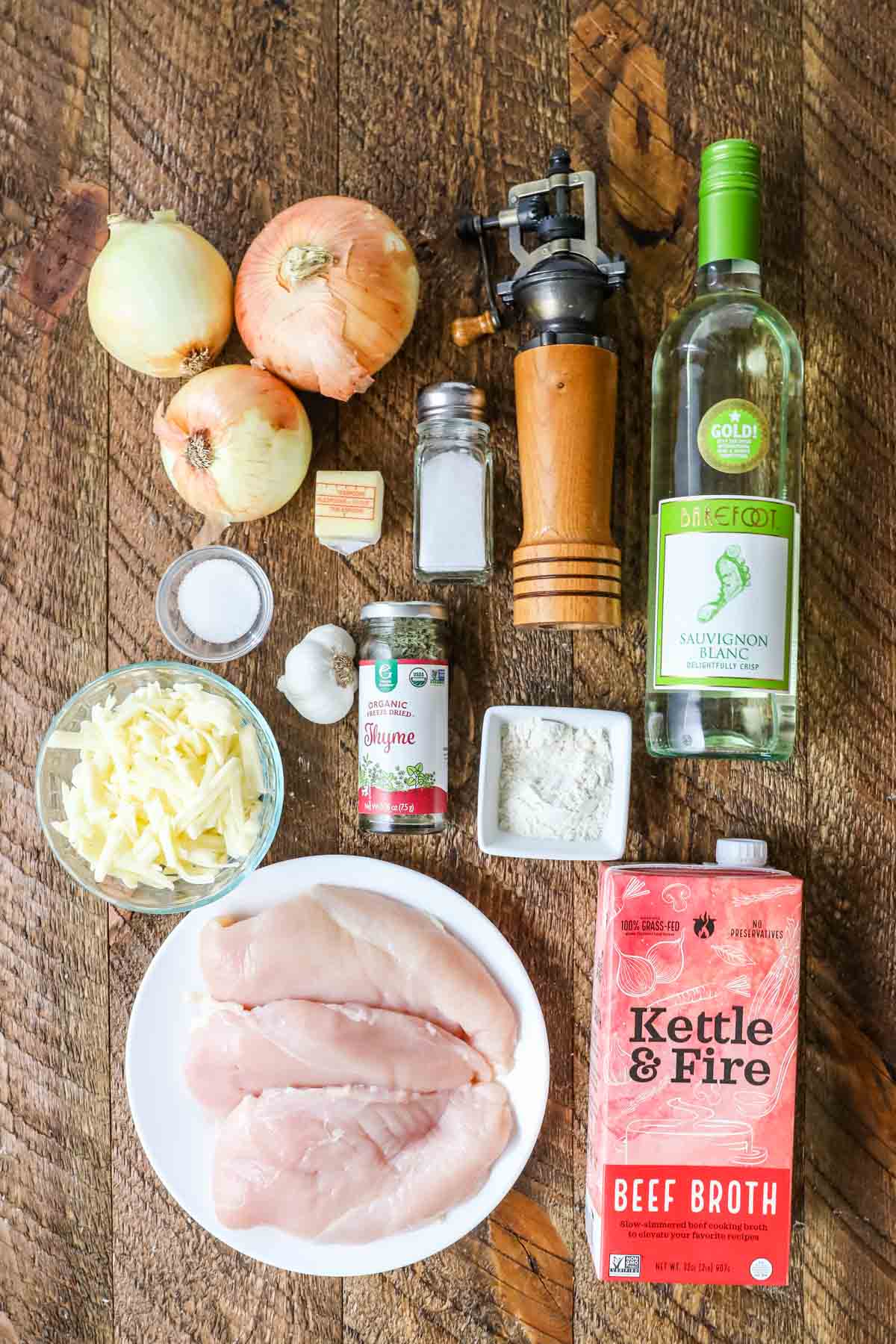 Overhead view of ingredients including white wine, onions, gruyere cheese, and more.