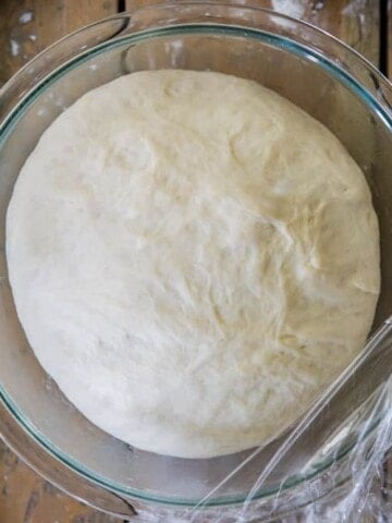 Pizza dough in glass bowl, after rising