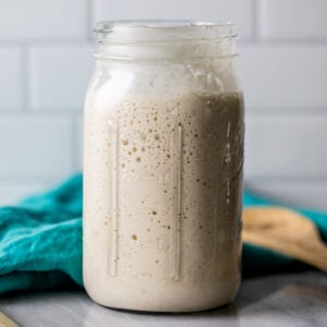 Large glass jar of sourdough starter.