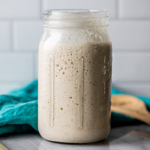 Large glass jar of sourdough starter.