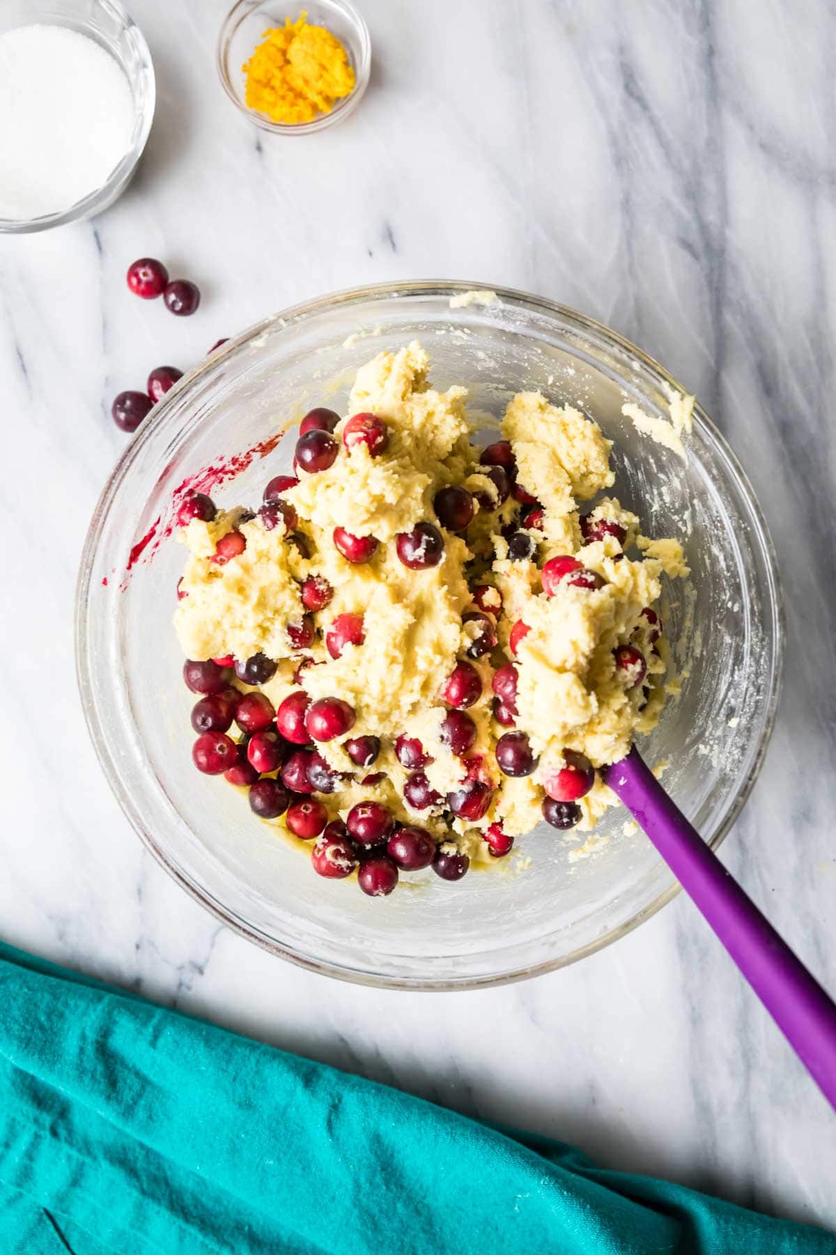 Overhead view of a bowl of cookie dough with fresh cranberries folded in.