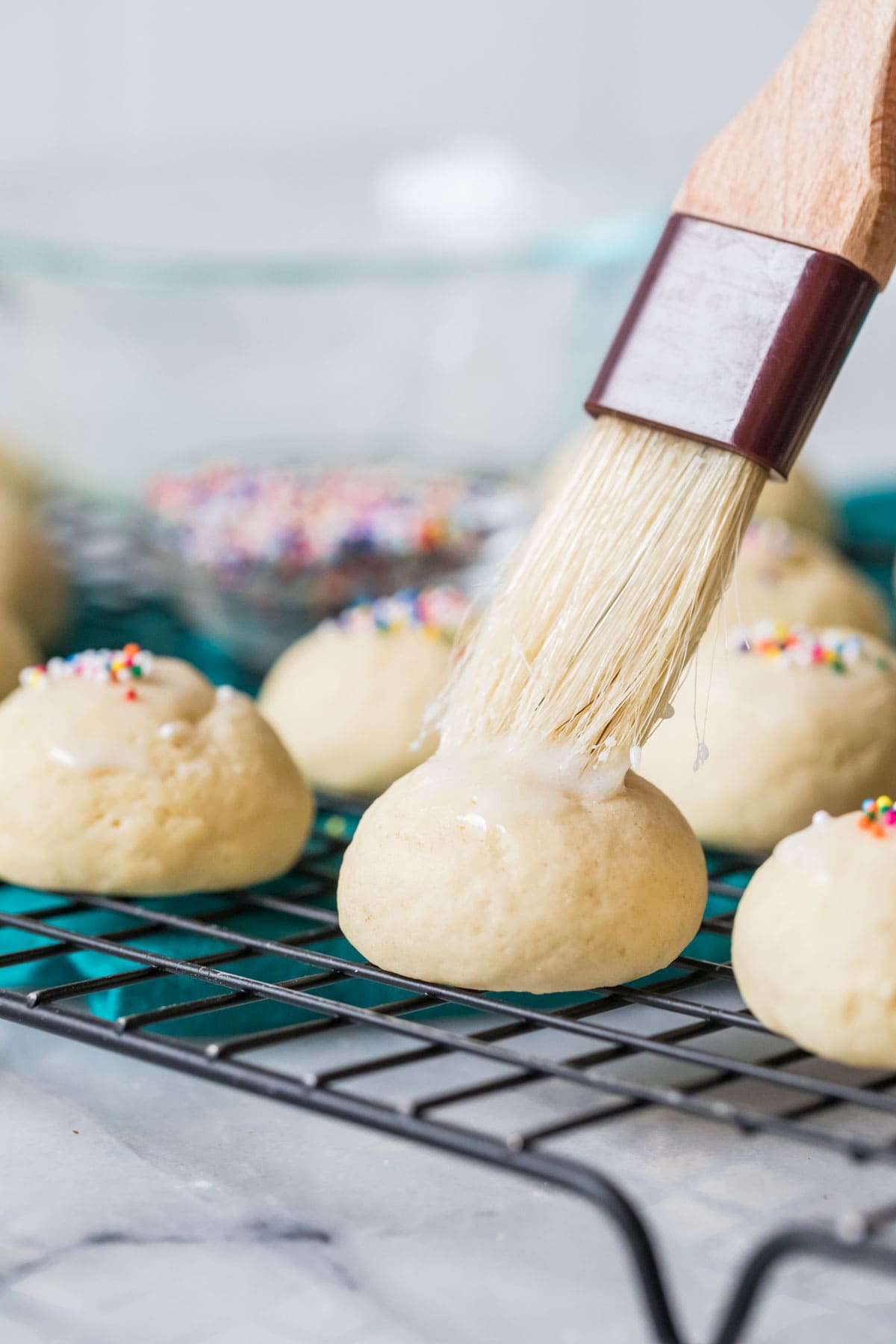 Cookie being brushed with glaze.