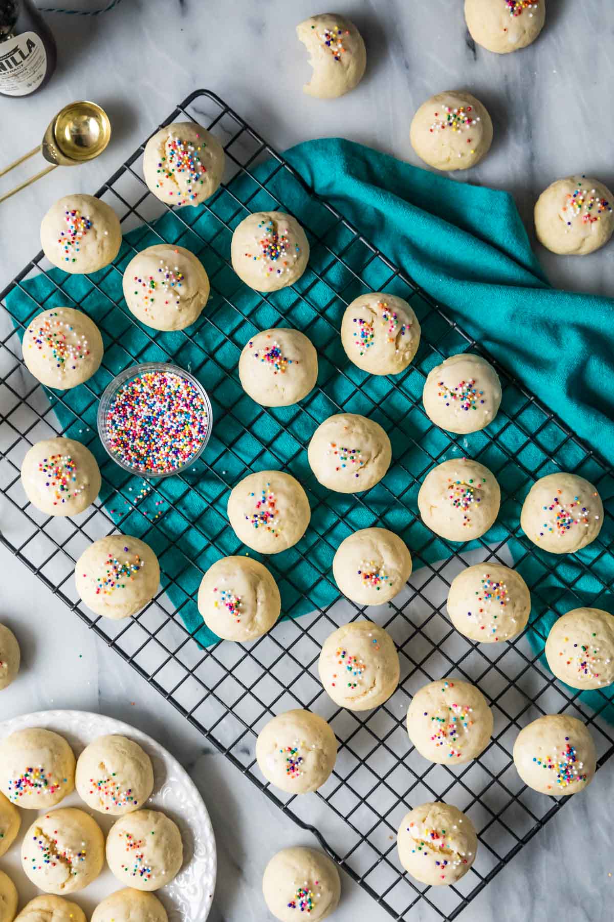 Overhead view of small, round cookies topped with rainbow sprinkles.