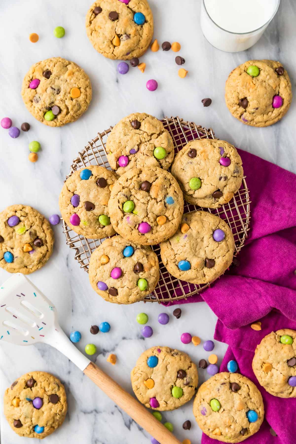 Overhead view of a cooling rack with monster cookies on top and scattered around.