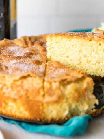 Slices being cut and served from an olive oil cake.