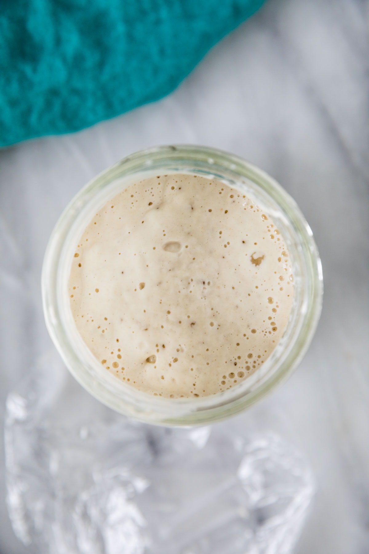 Overhead view of a bubbly mixture in a glass jar.