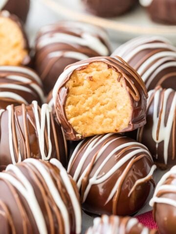 chocolate coated peanut butter ball bitten to show peanut butter center arranged among other decorated balls