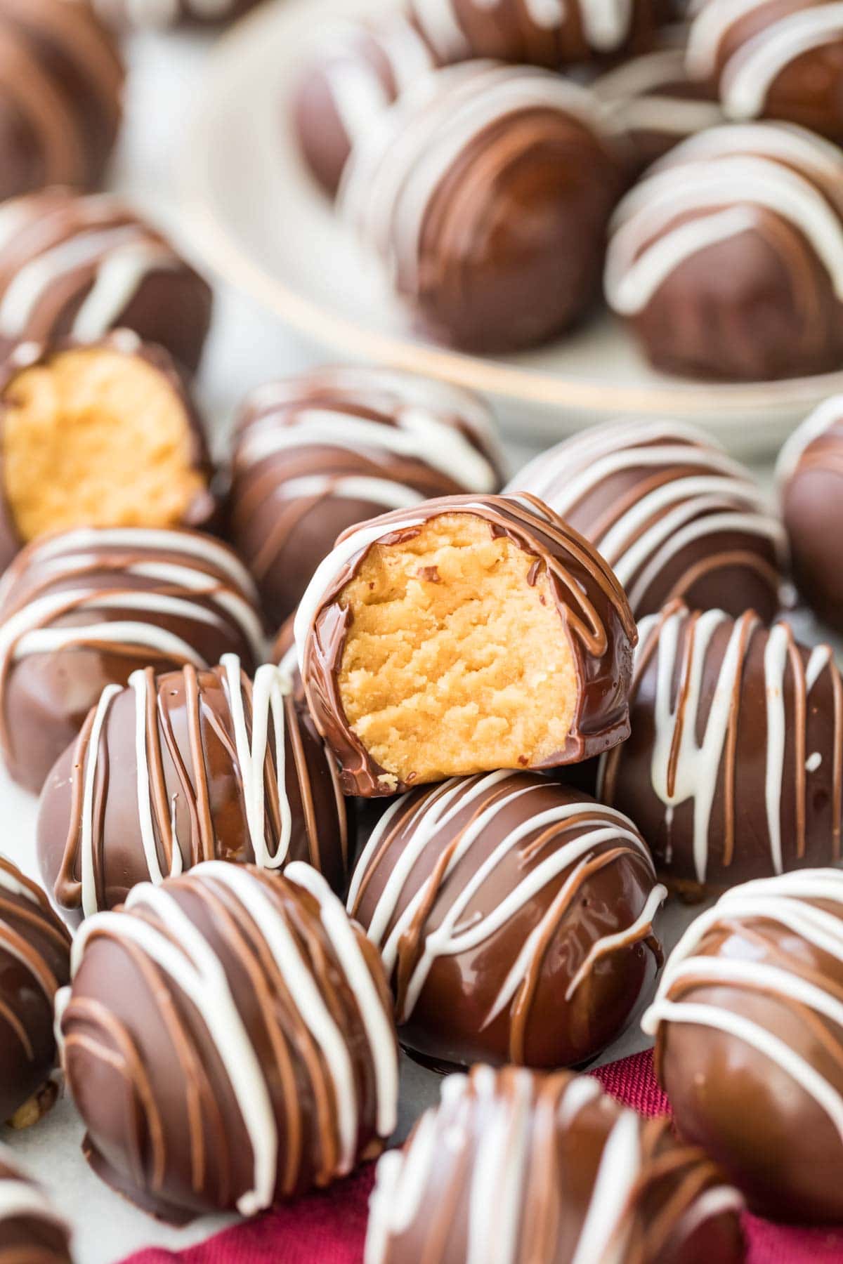 chocolate coated peanut butter ball bitten to show peanut butter center arranged among other decorated balls