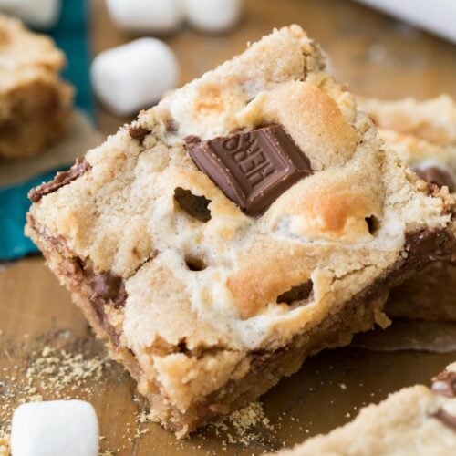Peanut butter s'mores bar with chocolate bar pieces pressed into the top surrounded by mini marshmallows.