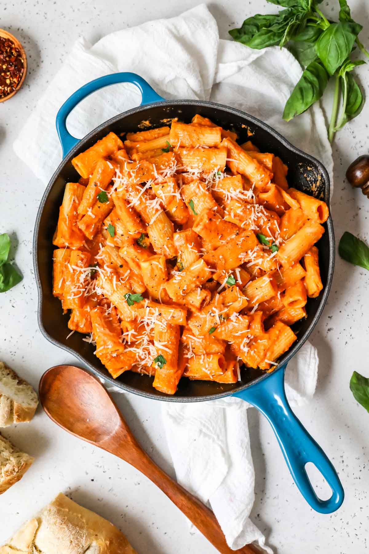 Overhead view of pink sauce pasta in a blue cast iron skillet.