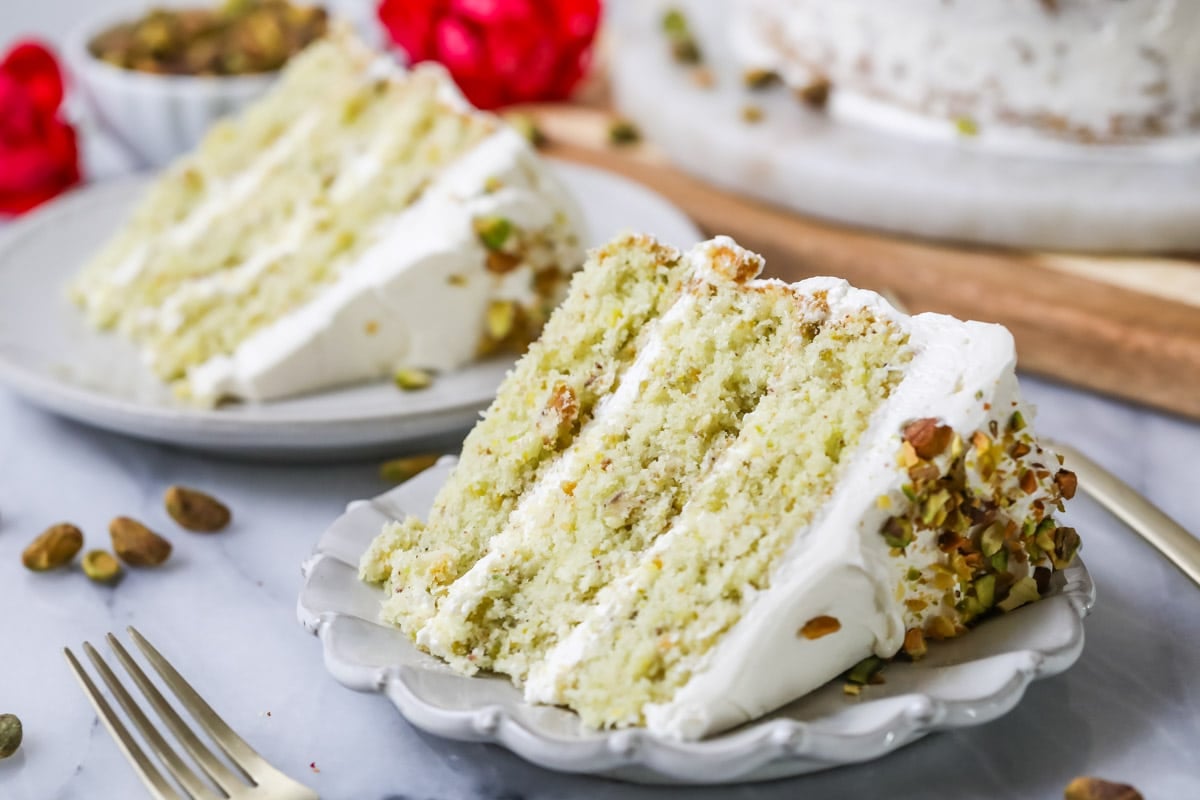 Slices of pistachio cake on white plates.