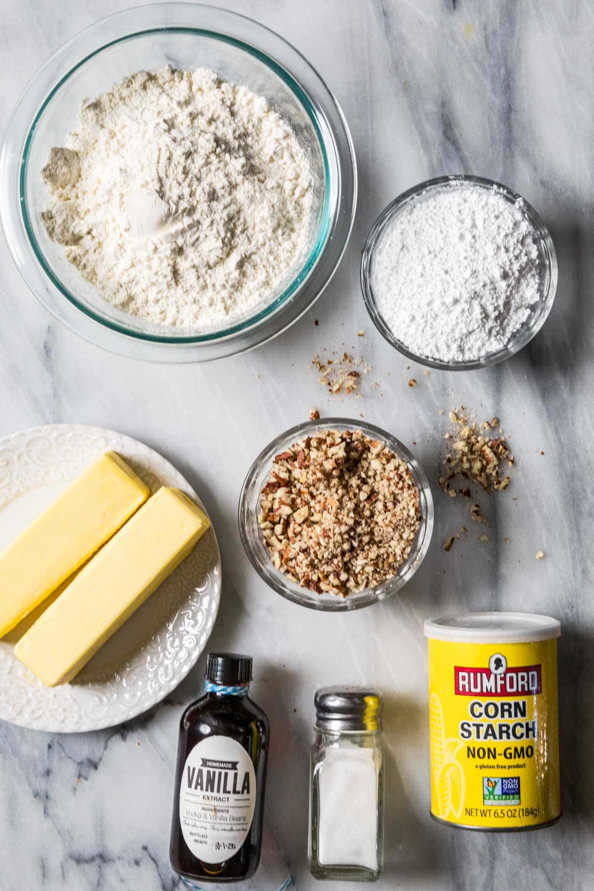 Overhead view of ingredients including nuts, cornstarch, powdered sugar, and more.